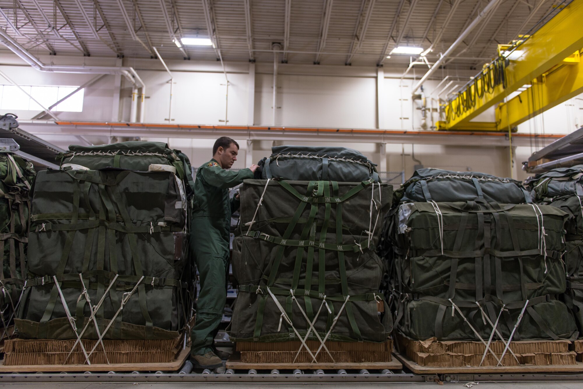 U.S. Air Force Senior Airman Andrew Fox, 36th Airlift Squadron joint airdrop inspector, inspects the parachute on a container delivery system bundle during Red Flag Alaska on Joint Base Elmendorf-Richardson, Alaska, Aug. 11, 2016. JAI's must perform two inspections; one before loading to ensure cargo is aircraft ready and rigged in accordance with proper rigging procedures and an after inspection of the cargo once it's been completely loaded on the aircraft. (U.S. Air Force photo by Staff Sgt. Michael Smith/Released)