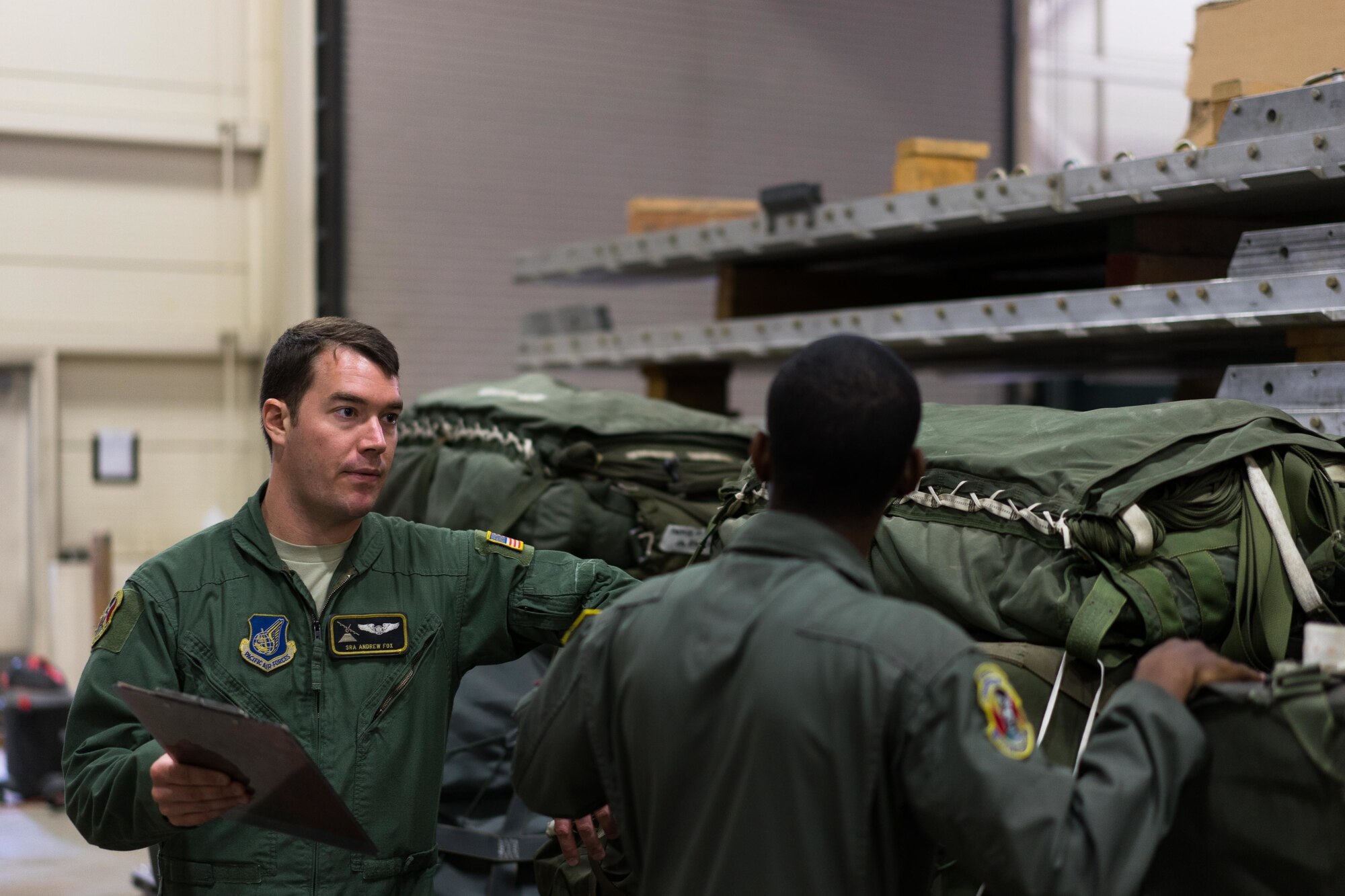 U.S. Air Force Senior Airman Andrew Fox and Senior Adrian Robinson, 36th Airlift Squadron joint airdrop inspectors, go over inspection procedures of a container delivery system bundle during Red Flag Alaska on Joint Base Elmendorf-Richardson, Alaska, Aug. 11, 2016. JAI's must perform two inspections; one before loading to ensure cargo is aircraft ready and rigged in accordance with proper rigging procedures and an after inspection of the cargo once it's been completely loaded on the aircraft. (U.S. Air Force photo by Staff Sgt. Michael Smith/Released)