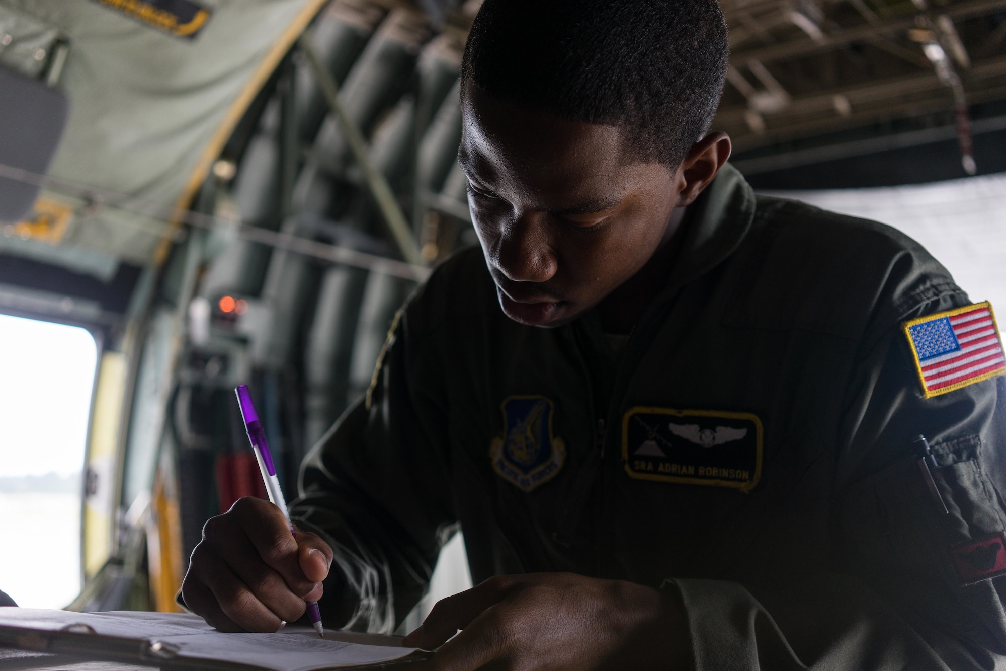 U.S. Air Force Senior Airman Adrian Robinson, 36th Airlift Squadron joint airdrop inspector, signs off on a completed inspection of a container delivery system bundle during Red Flag Alaska on Joint Base Elmendorf-Richardson, Alaska, Aug. 12, 2016. JAI's must perform two inspections; one before loading to ensure cargo is aircraft ready and rigged in accordance with proper rigging procedures and an after inspection of the cargo once it's been completely loaded on the aircraft. (U.S. Air Force photo by Staff Sgt. Michael Smith/Released)