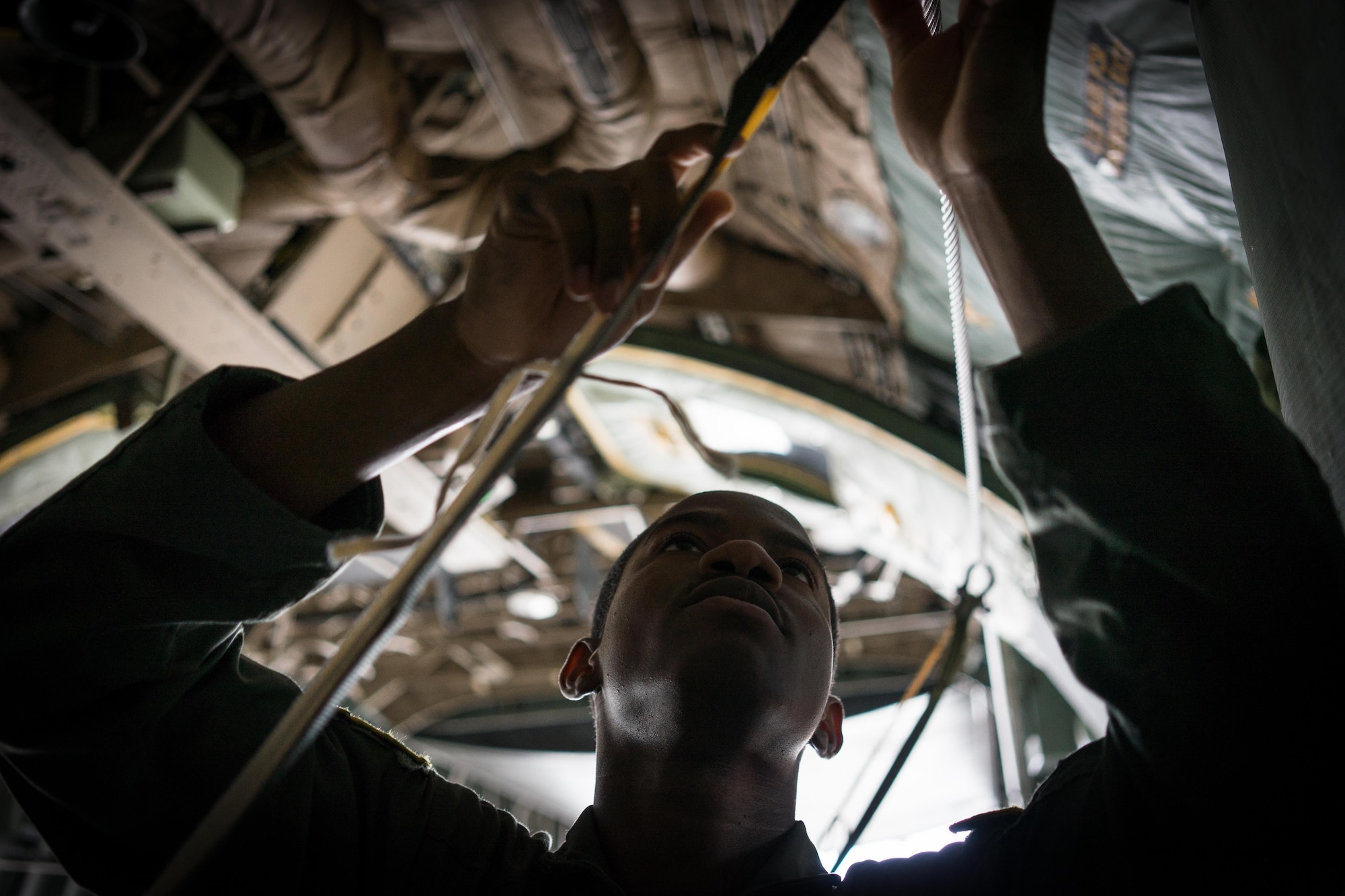 U.S. Air Force Senior Airman Adrian Robinson, 36th Airlift Squadron joint airdrop inspector, inspects the static line rigging on a container delivery system bundle during Red Flag Alaska on Joint Base Elmendorf-Richardson, Alaska, Aug. 12, 2016. Bundles that are improperly rigged can lead to malfunctions which hold the risk of damaging aircraft, personnel and can lead to mission failure. (U.S. Air Force photo by Staff Sgt. Michael Smith/Released)