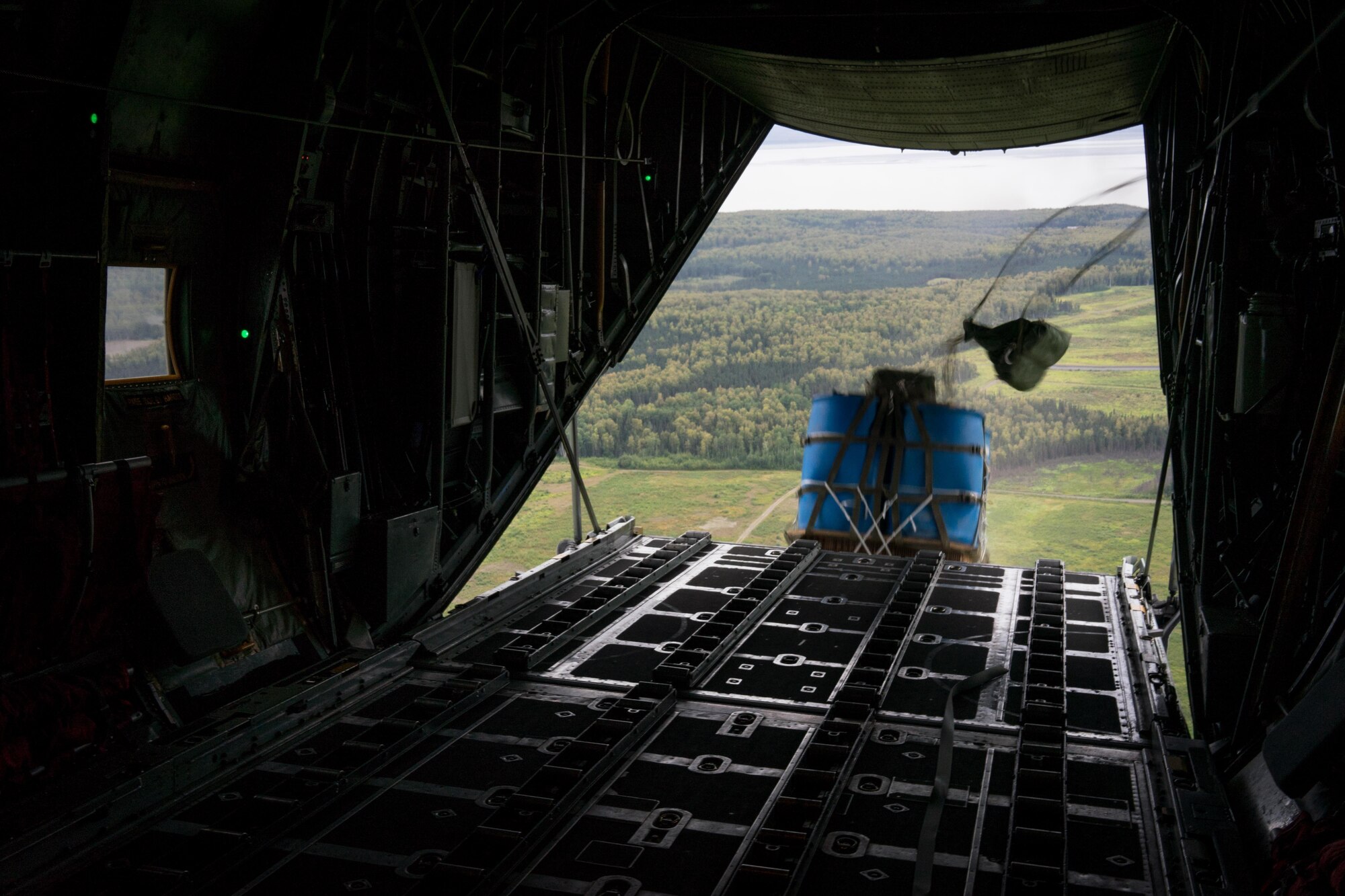 A container delivery system bundle drops from a C-130 Hercules during Red Flag Alaska on Joint Base Elmendorf-Richardson, Alaska, Aug. 12, 2016. Instead of being pushed out of the plane by a loadmaster, cds bundles are ejected using only the forward momentum of the aircraft. (U.S. Air Force photo by Staff Sgt. Michael Smith/Released)