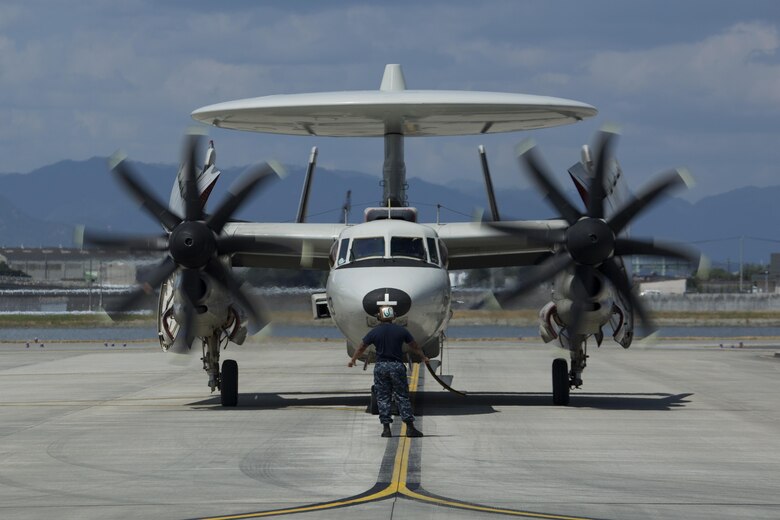 A U.S. Navy E-2C Hawkeye assigned to Carrier Airborne Early Warning Squadron (VAW) 115, with Carrier Air Wing 5, taxis into hot refueling pits at Marine Corps Air Station Iwakuni, Japan, Aug. 17, 2016. While passing through the air station for aircraft-based training, maintainers inspected and refueled the Hawkeyes before their retrograde back to Naval Air Facility Atusgi. The all-weather, carrier-based, tactical battle management airborne early warning command and control aircraft became operational in 1973 and underwent several upgrades. Variants of this aircraft are also flown by the Egyptian Air Force, Japanese Air Self-Defense Force, Republic of Singapore Air Force, Taiwan Air Force, and the French Navy. (U.S. Marine Corps photo by Lance Cpl. Donato Maffin)