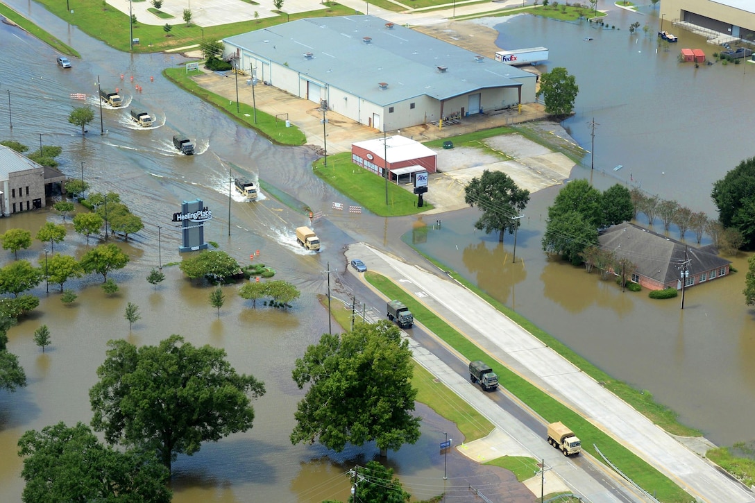 Army tactical vehicles transport flood relief supplies along a highway in Denham Springs, La., Aug. 15, 2016, after more than 30 inches of rainfall caused severe flooding in southeast portions of the state. The soldiers and vehicles are assigned to the Louisiana Army National Guard, which has mobilized more than 1,000 personnel to respond to the flooding. Army National Guard photo by 1st Sgt. Paul Meeker