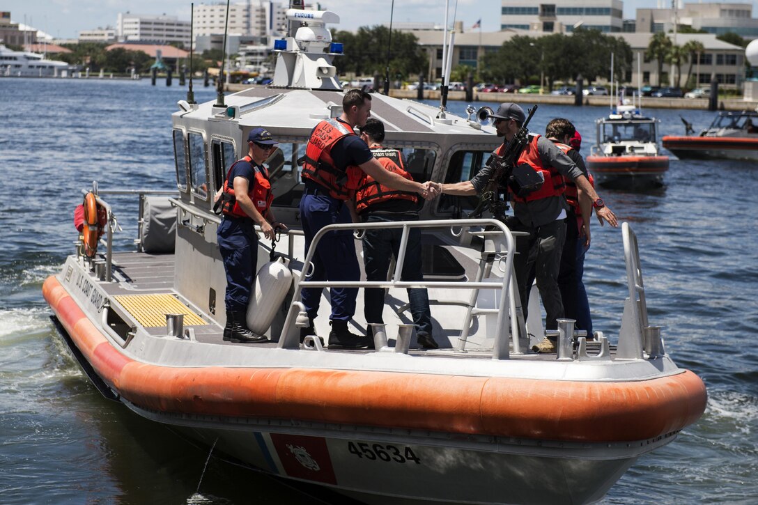 Participants in the Joint Civilian Orientation Conference meet crew members of a Coast Guard response boat at Coast Guard Sector St. Petersburg, Fla., Aug. 16, 2016. The conference aims to increase public understanding of the nation's defense by allowing American business and community leaders observe and engage with the U.S. military. DoD photo by Marine Sgt. Drew Tech