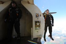 A member of the U.S. Army Golden Knights salutes as he jumps out of a plane as another member prepares to jump at the Northern Neighbors Day Air Show at Minot Air Force Base, N.D., Aug. 13, 2016. The team performs parachute demonstrations at air shows, major league football and baseball games, and other special events, connecting the Army with the American people. (U.S. Air Force photo/Senior Airman Kristoffer Kaubisch)