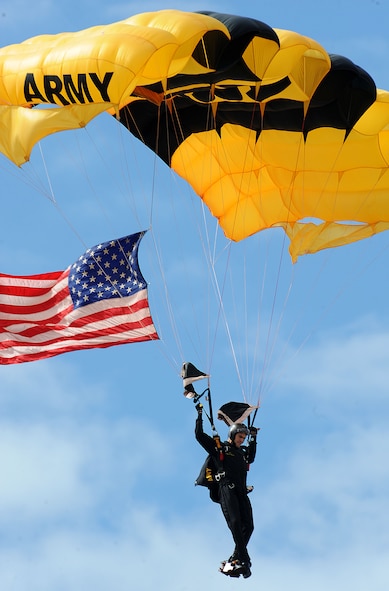 A member of the U.S. Army Golden Knights parachutes down with the American flag during the national anthem at Northern Neighbors Day Air Show at Minot Air Force Base, N.D., Aug. 13, 2016. The team performs parachute demonstrations at air shows, major league football and baseball games, and other special events, connecting the Army with the American people. (U.S. Air Force photo/Senior Airman Kristoffer Kaubisch)