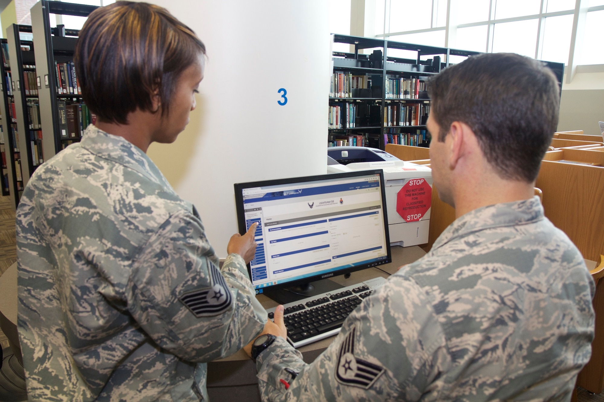 Technical Sgt. Tia Strong and Staff Sgt. Andrew Daily, instructors with the United States Air Force School of Aerospace Medicine's Department of Occupational & Environmental Health, navigate Blackboard, the
commercially-hosted Learning Management System the School has contracted with to modernize its training platforms. (U.S. Air Force photo/David W. Snedigar)
