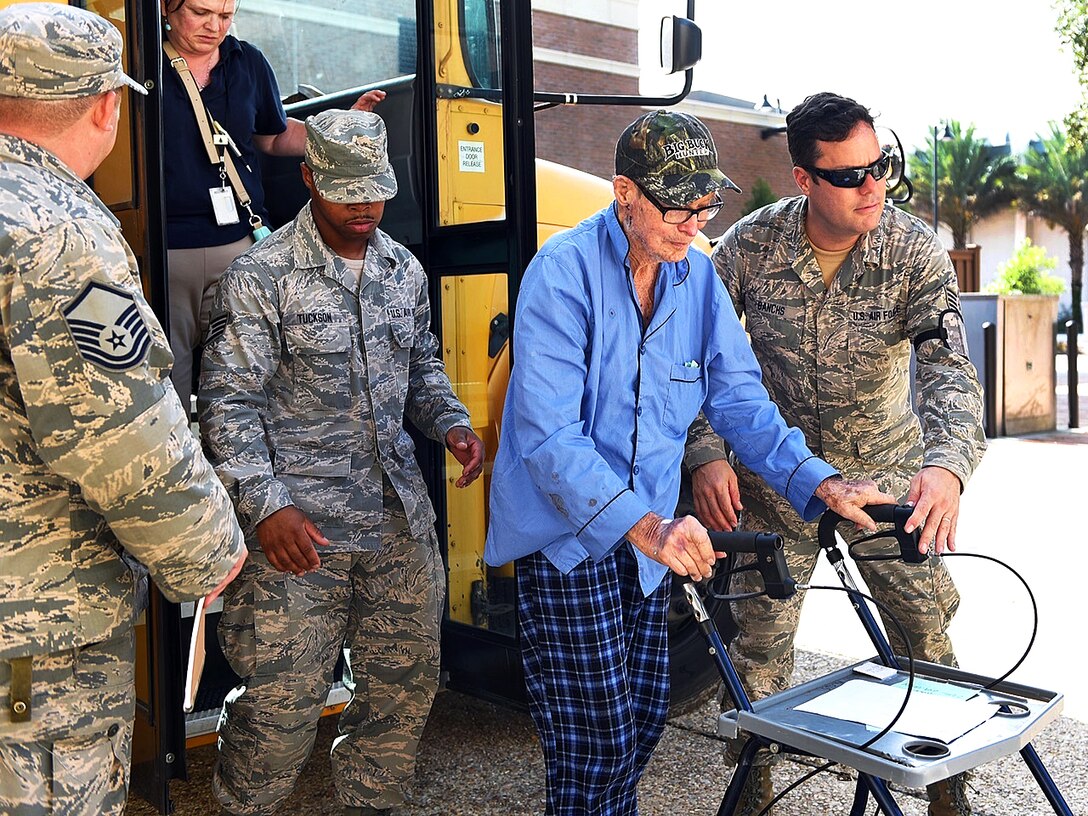 Airmen transport flood evacuee Willis Woods, a World War II veteran, from the Celtic Media Centre shelter to a special needs facility near the Louisiana State University campus in Baton Rouge, La., Aug. 15, 2016. The airmen are assigned to the Louisiana Air National Guard’s 159th Fighter Wing. The Louisiana National Guard has mobilized more than 1,000 personnel in response to severe flooding. Air National Guard photo by Master Sgt. Dan Farrell