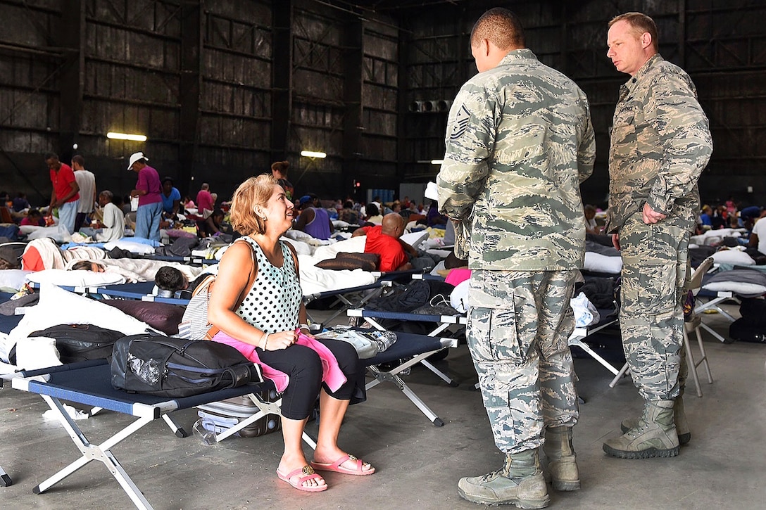 Air Force Lt. Col. Kelly Sullivan and 1st Sgt. Marvin Vides talk to one of numerous residents evacuated to a makeshift shelter in a movie studio near the Celtic Media Centre in Baton Rouge, La., Aug. 15, 2016. Sullivan and Vides are assigned to the Louisiana Air National Guard’s 122nd Air Support Operations Squadron. Air National Guard photo by Master Sgt. Dan Farrell