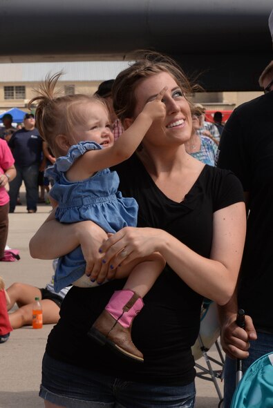 A young girl points to the sky during the Northern Neighbors Day Air Show at Minot Air Force Base, N.D., Aug. 13, 2016. Patrons were able to enjoy aerobatic stunts performed by Kent Pietsch in the Jelly Belly aircraft. (U.S. Air Force photo/Airman 1st Class Jessica Weissman)