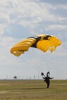 A member of the U.S. Army Golden Knights performs a stand-up landing at the Northern Neighbors Day Air Show at Minot Air Force Base, N.D., Aug. 13, 2016. The Golden Knights tests and evaluates new parachuting equipment and techniques to assist in improving operations and safety for military freefall teams. (U.S. Air Force photo/Airman 1st Class Jessica Weissman)