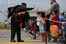 U.S. Army Sgt. 1st Class Kevin Presgraves, team leader of the U.S. Army Golden Knights black demonstration team, high fives a child at the Northern Neighbors Day Air Show at Minot Air Force Base, N.D., Aug. 13, 2016. Presgraves has logged more than 2,700 freefall parachute jumps. (U.S. Air Force photo/Airman 1st Class Jessica Weissman)