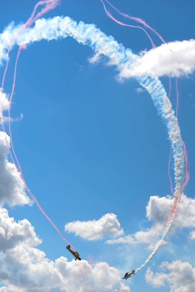 The Kent Pietsch Jelly Belly aircraft and Jim Peitz Beechcraft Bonanza performs aerial stunts during the Northern Neighbors Day Air Show at Minot Air Force Base, N.D., Aug. 13, 2016. With over 40 years of experience and a thousand flying hours, both pilots have unique aircraft to entertain spectators of all ages. 