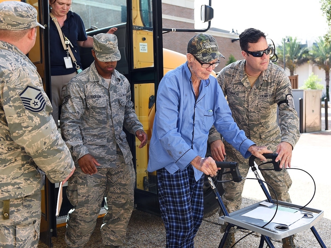 Members of the 159th Fighter Wing, Louisiana Air National Guard transport flood evacuee and World War II veteran, Mr. Willis Woods from the Celtic Media Centre shelter to a special needs facility near the Louisiana State University campus on August 15, 2016.  The Louisiana National Guard mobilized more than 1,000 guardsmen in response to heavy flash flooding that occurred in south Louisiana on August 13, 2006. 