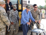 Members of the 159th Fighter Wing, Louisiana Air National Guard transport flood evacuee and World War II veteran, Mr. Willis Woods from the Celtic Media Centre shelter to a special needs facility near the Louisiana State University campus on August 15, 2016.  The Louisiana National Guard mobilized more than 1,000 guardsmen in response to heavy flash flooding that occurred in south Louisiana on August 13, 2006. 