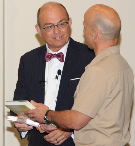 DAHLGREN, Va. - Capt. Brian Durant, Naval Surface Warfare Center Dahlgren Division (NSWCDD) commander, presents the Dahlgren history book, "The Sound of Freedom," to U.S. Department of the Air Force General Counsel Gordon Tanner, at the NSWCDD sponsored 2016 Lesbian, Gay, Bisexual and Transgender (LGBT) Pride Month Observance, June 22. Eight days after the Dahlgren LGBT observance, Secretary of Defense Ash Carter announced that transgender individuals will be able to openly serve in the U.S. armed forces. Effective June 30, 2016 - service members may no longer be involuntarily separated, discharged or denied reenlistment solely on the basis of gender identity. Service members currently on duty will be able to serve openly. 