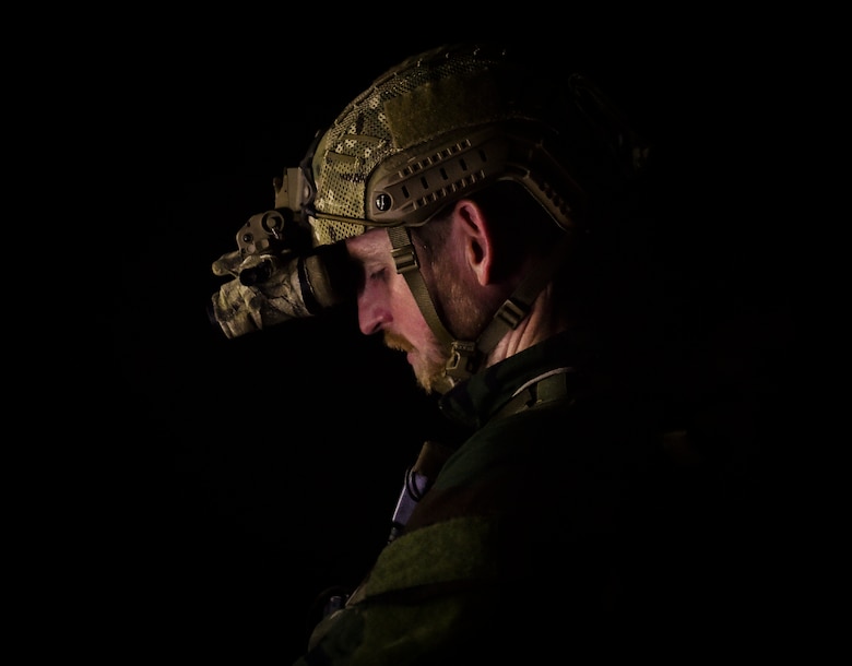 A 352nd Battlefield Airmen Training Squadron Combat Control School instructor dons a night-optics device, acting as an opposing force during a tactics field training exercise at Camp Mackall, N.C., Aug. 3, 2016. The 352nd BA TS, or Combat Control School, is the home of a 13-week course that provides initial CCT qualifications. The training includes, small unit tactics, land navigation, communications, assault zones, physical training demolitions, fire support and field operations including parachuting. At the completion of this course, each graduate is awarded the three-skill level, scarlet beret and CCT flash. (U.S. Air Force photo by Senior Airman Ryan Conroy)