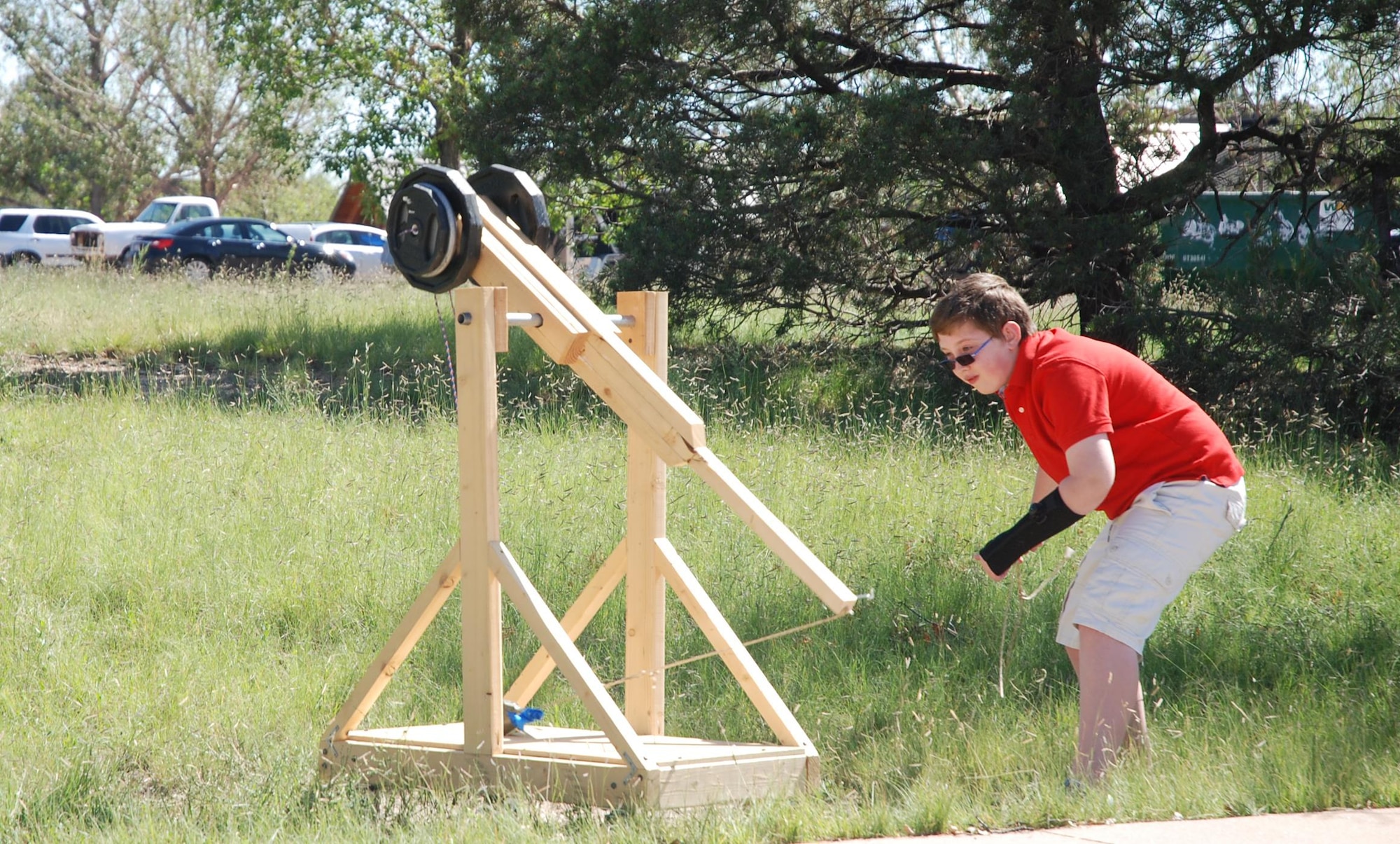 Ian Porter, 12-year-old son of Staff Sgt. Adam Porter, concert band operations manager for the U.S. Air Force Academy Band, prepares to launch a baseball from a trebuchet at the STARBASE Academy on Peterson Air Force Base, Colo., Aug. 12, 2016. Ian donated the device and a torsion catapult he built to the STARBASE Academy to use as a teaching aid. The Porters are moving to Germany and cannot take them along. (U.S. Air Force photo by Dave Smith)