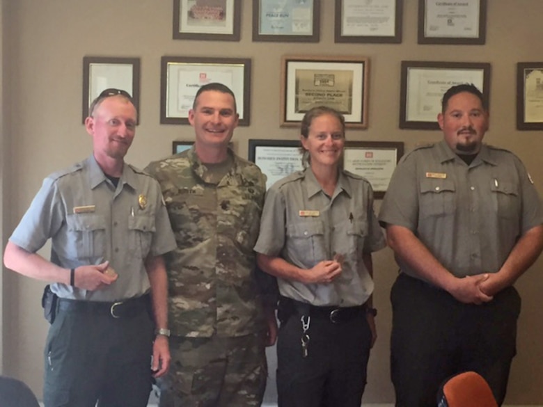 ABIQUIU LAKE, N.M. – District Commander Lt. Col. James Booth presents park rangers (l-r) Austin Kuhlman, Leigh Ann Kirkeeide and Daniel Archuleta with commander’s coins, Aug. 12, 2016.  (Ranger Nathaniel Naranjo not pictured). The rangers were recognized for rescuing a man from drowning at the lake on July 30.
