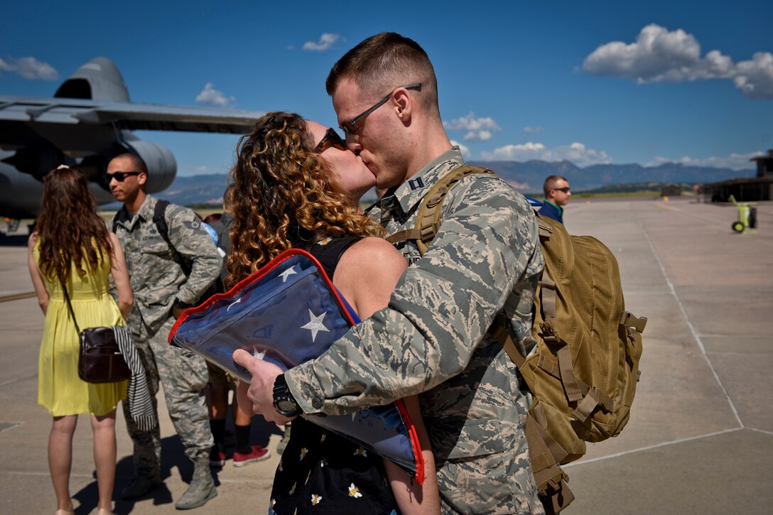 An Airman from the 4th Space Control Squadron embraces his significant other on the flightline at Peterson Air Force Base, Colo., Aug. 13, 2016. The unit just returned from deployment and happily met their waiting families. (U.S. Air Force photo by Senior Airmen Rose Gudex)