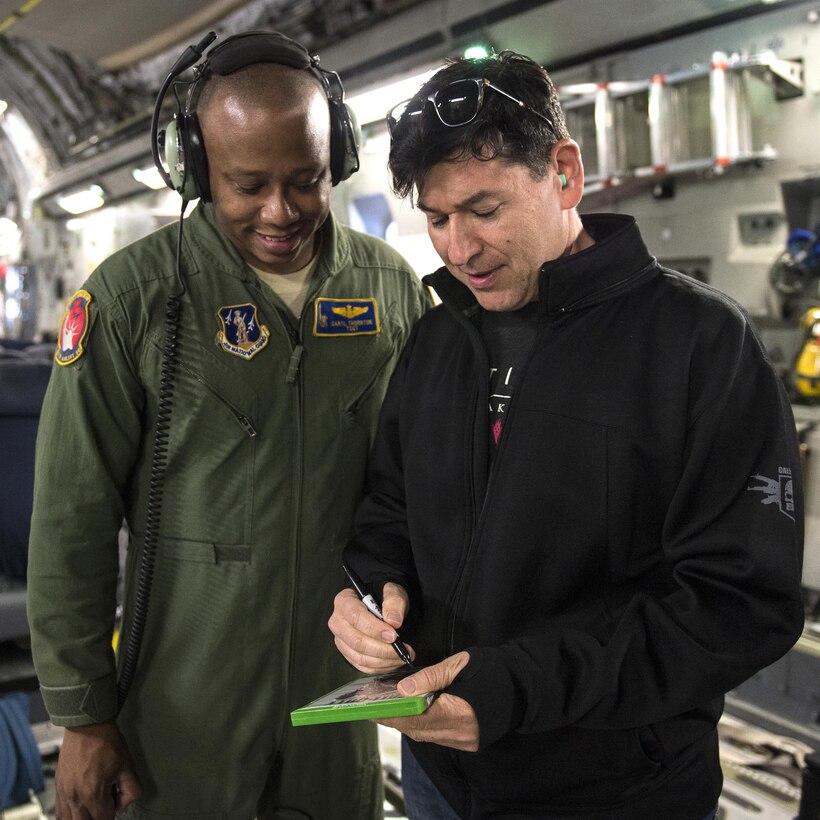 Adam Foshko, right, director of story development for Activision, signs a copy of his video game, "Call of Duty," for Air Force Tech. Sgt. Daryl Thornton in St. Petersburg, Fla., Aug. 16, 2016, during the Joint Civilian Orientation Conference. Thornton is a loadmaster assigned to the 137th Airlift Squadron. DoD photo by Marine Sgt. Drew Tech