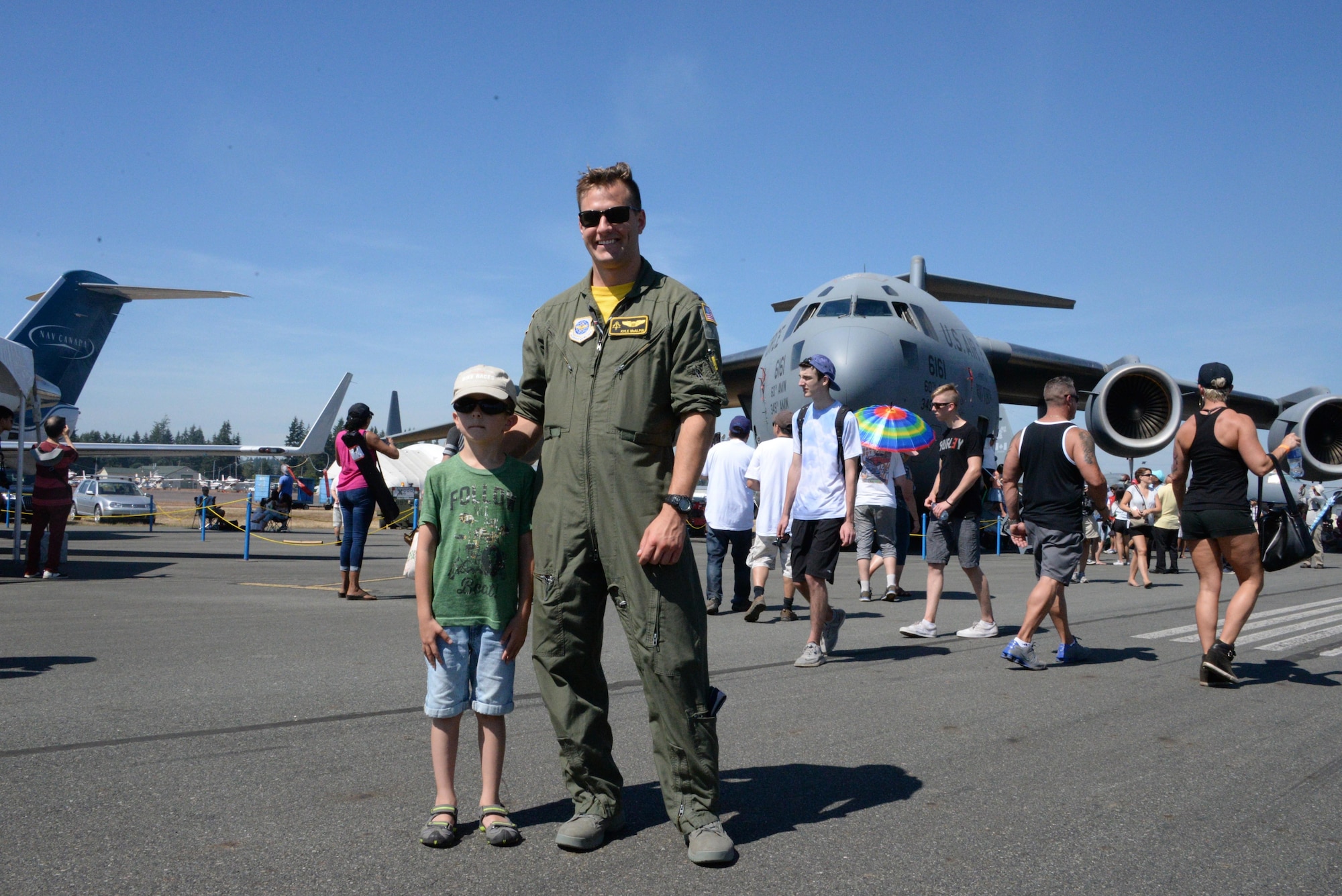 Capt. Kyle McAplin, 21st Airlift Squadron pilot, poses with a visitor in front of a C-17 Globemaster III at the Abbotsford International Airshow, in Abbotsford, British Columbia, Aug. 13, 2016. Designated as Canada’s National Airshow, the annual aviation festival provided spectators an opportunity to watch one of the finest aerobatic performances in the world.  (U.S. Air Force photo by 2nd Lt. Geneva Croxton)