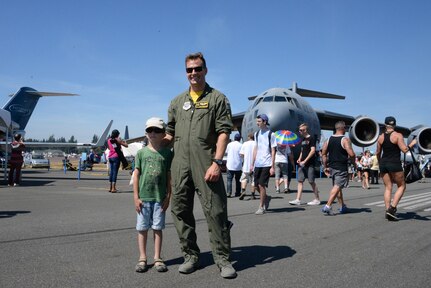 Capt. Kyle McAplin, 21st Airlift Squadron pilot, poses with a visitor in front of a C-17 Globemaster III at the Abbotsford International Airshow, in Abbotsford, British Columbia, Aug. 13, 2016. Designated as Canada’s National Airshow, the annual aviation festival provided spectators an opportunity to watch one of the finest aerobatic performances in the world.  (U.S. Air Force photo by 2nd Lt. Geneva Croxton)