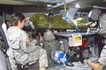 Students in the Flight Paramedic Recertification Course at the U.S. Army Medical Department Center and School at Fort Sam Houston practice loading an injured Soldier inside the Training Mobile Transport Lab, a life-sized UH-60 helicopter platform.