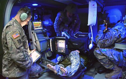 Flight paramedic course instructor Sgt. 1st Class Reid Carpenter (left) wirelessly adjusts the setting of a medical patient simulator as two Army health care specialists, who are paramedic-qualified, practice treating an injured patient inside a UH-60 Blackhawk helicopter trainer. The life-sized trainer offers students the opportunity of realistic classroom exercises emulating the sound, wind, and stressful environment of an actual helicopter. The advanced patient simulators used at AMEDDC&S provide students with vital signs, clinical signs, and symptoms mimicking live patients.