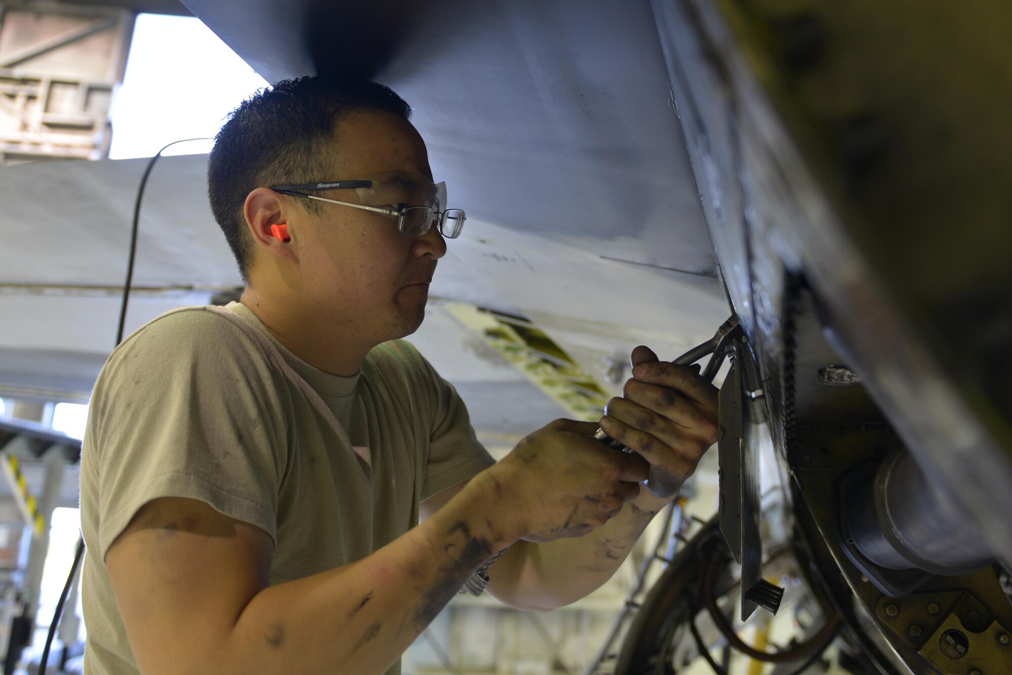 U.S. Air Force Staff Sgt. Jeffrey Jin, a 354th Maintenance Squadron aerospace propulsion craftsman, removes a panel from an F-16 Fighting Falcon aircraft Aug. 12, 2016, during RED FLAG-Alaska 16-3, in the phase shop at Eielson Air Force Base, Alaska. Jin is preparing the aircraft for its engine to be removed so the joint service electronic combat systems tester can be fixed. (U.S. Air Force photo by Airman Isaac Johnson)
