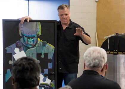 Retired Master Sgt. Cody Vance speaks about his vision behind creating his Post-traumatic Stress Disorder art piece during an Open the Door Veterans’ Project event. The Post-traumatic Stress Disorder art has been reproduced and seen all over the world and is currently part of the Pentagon’s Air Force Art Program. (Courtesy photo)