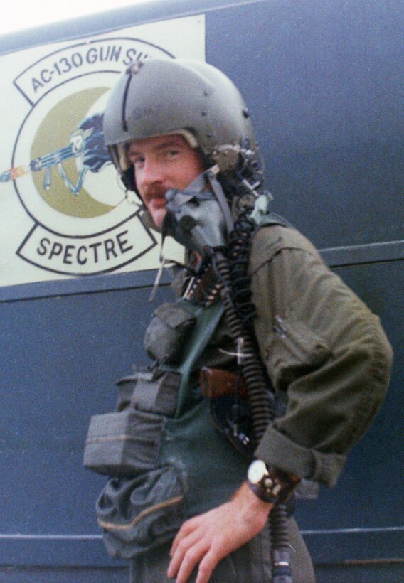 Capt. Robert Allen, 62nd Airlift Wing historian, poses for a photo in front of an AC-130 Spectre sign in 1972 at Ubon Royal Thai Air Force Base, Thailand. While stationed in Thailand, Allen flew as a navigator in AC-130’s over Vietnam. (Courtesy photo) 