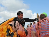 A member of the U.S. Army Golden Knights engages with a fan after his parachute jump during Northern Neighbors Day Air Show at Minot Air Force Base, N.D., Aug. 13, 2016. The Golden Knights are a parachute team who travel around the U.S. to perform at various demonstrations and competitions. (U.S. Air Force photo/Airman 1st Class Jonathan McElderry)
