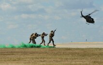 Airmen with the 791st Missile Security Forces Squadron Tactical Response Force team demonstrate how they would act in a deployed environment during the Northern Neighbors Day Air Show at Minot Air Force Base, N.D., Aug. 13, 2016. TRF Airmen go through rigorous training throughout the year in order to maintain mission readiness. (U.S. Air Force photo/Airman 1st Class Jonathan McElderry)