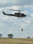 An Airman with the 791st Missile Security Forces Squadron Tactical Response Force team is airlifted into a helicopter during the Northern Neighbors Day Air Show at Minot Air Force Base, N.D., Aug. 13, 2016. TRF Airmen are trained to respond to any situation in a deployed environment. (U.S. Air Force photo/Airman 1st Class Jonathan McElderry)