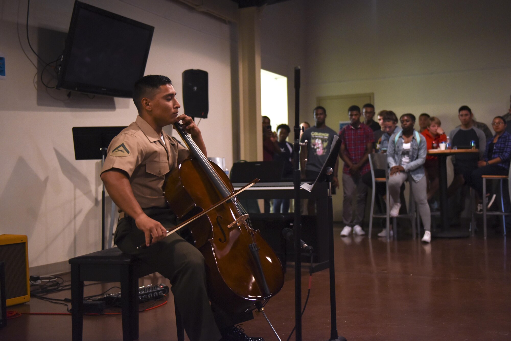 Goodfellow students watch a U.S. Marine playing the cello at Crossroads Student Center on Goodfellow Air Force Base, Texas, Aug. 13, 2016. The cellist demonstrated his skill in front of the crowd as part of Goodfellow’s Got Talent. (U.S. Air Force photo by Airman 1st Class Chase Sousa/Released)