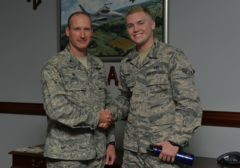 U.S. Air Force Col. Stephen Jost, 20th Fighter Wing commander, recognizes Airman 1st Class Bryan Clark, 20th FW command post controller, during an Airman Up! Award presentation at Shaw Air Force Base, S.C., Aug. 17, 2016.  Jost initiated Airman Up! to challenge personnel to develop personal skills and resiliency in all aspects of their lives. (U.S. Air Force Airman 1st Class Destinee Sweeney)