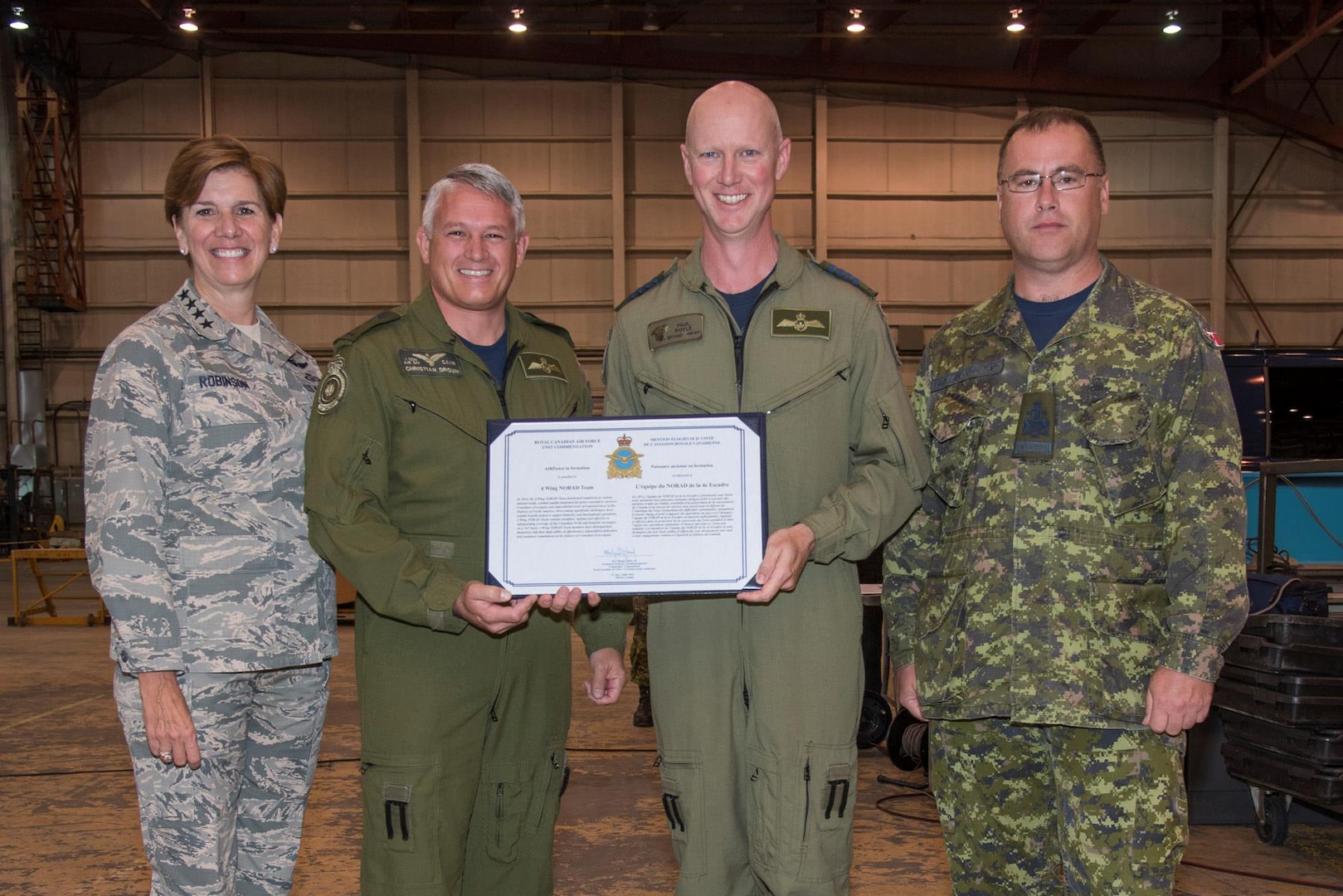 Major-General Christian Drouin, Commander of 1 Canadian Air Division, and General Lori Robinson, Commander of the North American Aerospace Defense Command and U.S. Northern Command,  presents a NORAD commendation to the 4 Wing Base Commander Colonel Paul Doyle and Acting 4 Wing Chief Warrant Officer Robert Brassington, at Hangar 1, 4 Wing Cold Lake, Alberta, Canada, Aug. 15, 2016.