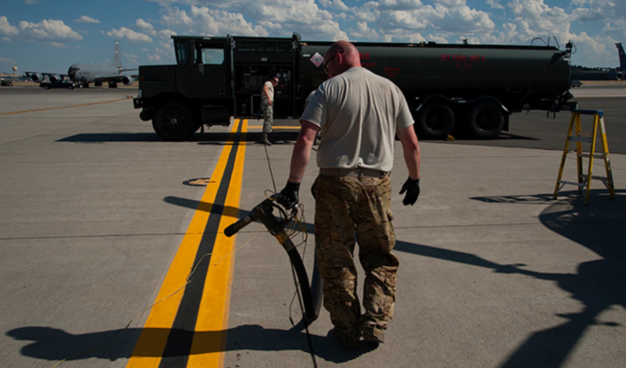 Airman 1st Class Michael Peek, 92nd Logistics Readiness Squadron refueling equipment operator, works with Staff Sgt. Scott Johnson, 140th Aviation Brigade, Washington Army National Guard, aircraft mechanic, to roll up a R-11 fuel truck hose after completing a refuel of a UH-72 Lakota helicopter July 25, 2016, at Fairchild Air Force Base, Wash. R-11 trucks can hold up to 6,000 gallons for fuel at a time. (U.S. Air Force photo/ Airman 1st Class Ryan Lackey)