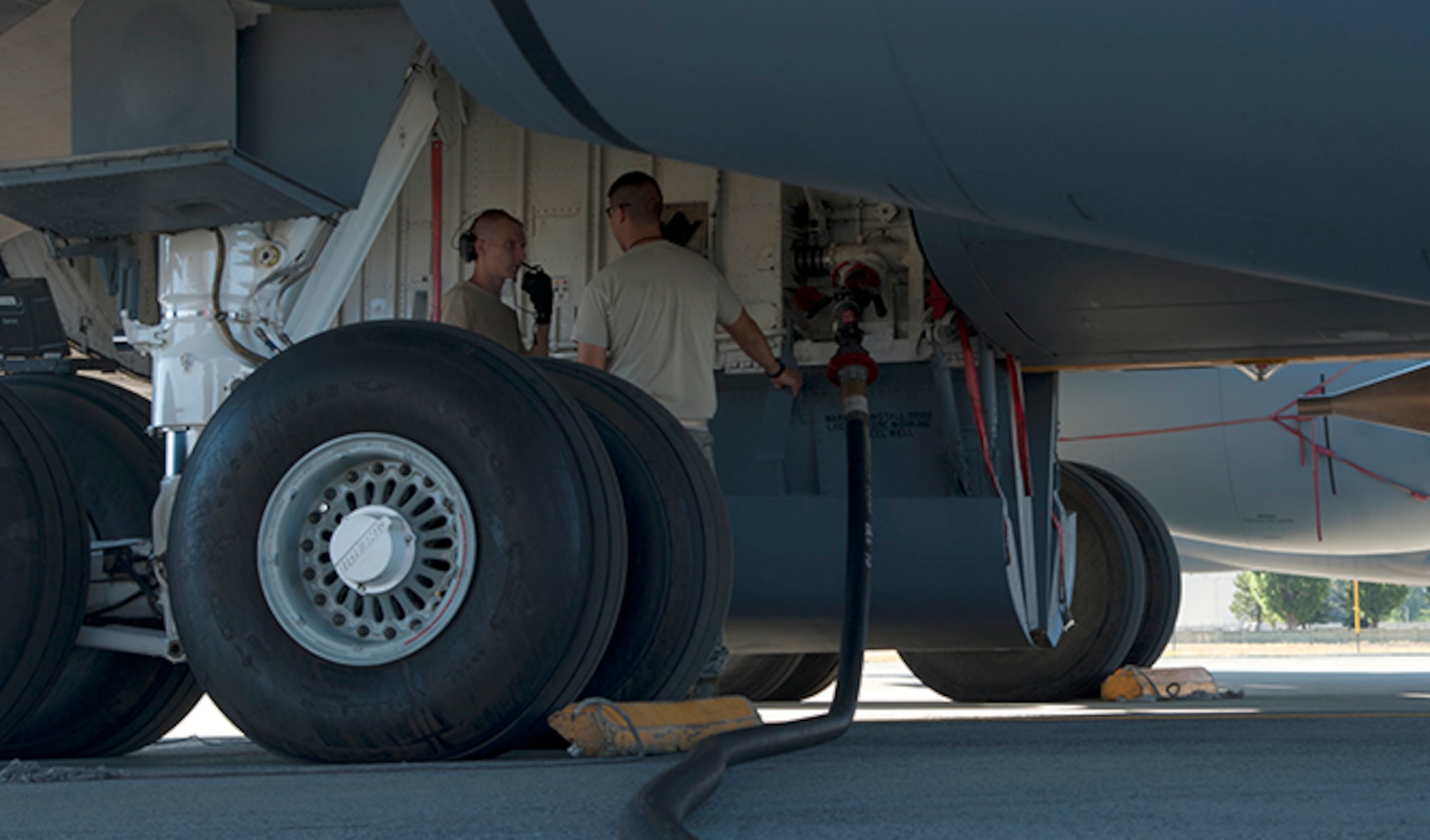 Airman 1st Class Thomas Fisher, 92nd Maintenance Group crew chief, discusses checklist items with another crew chief as his assigned KC-135 is being refueled Aug. 16, 2016, at Fairchild Air Force Base, Wash. Refueling actions on a dry KC-135 may take approximately an hour or longer depending on the demand for fuel at a given time. (U.S. Air Force photo/ Airman 1st Class Ryan Lackey)