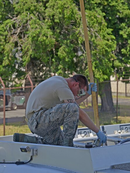 Senior Airman Robert Edmons, 374th Logistics Readiness Squadron fuels laboratory technician, collects a visual sample of JP8 fuel from a fuel truck at Yokota Air Base, Japan, Aug. 17, 2016. The visual inspection is performed to look for water or any other type of contamination. (U.S. Air Force photo by Senior Airman David Owsianka/Released)