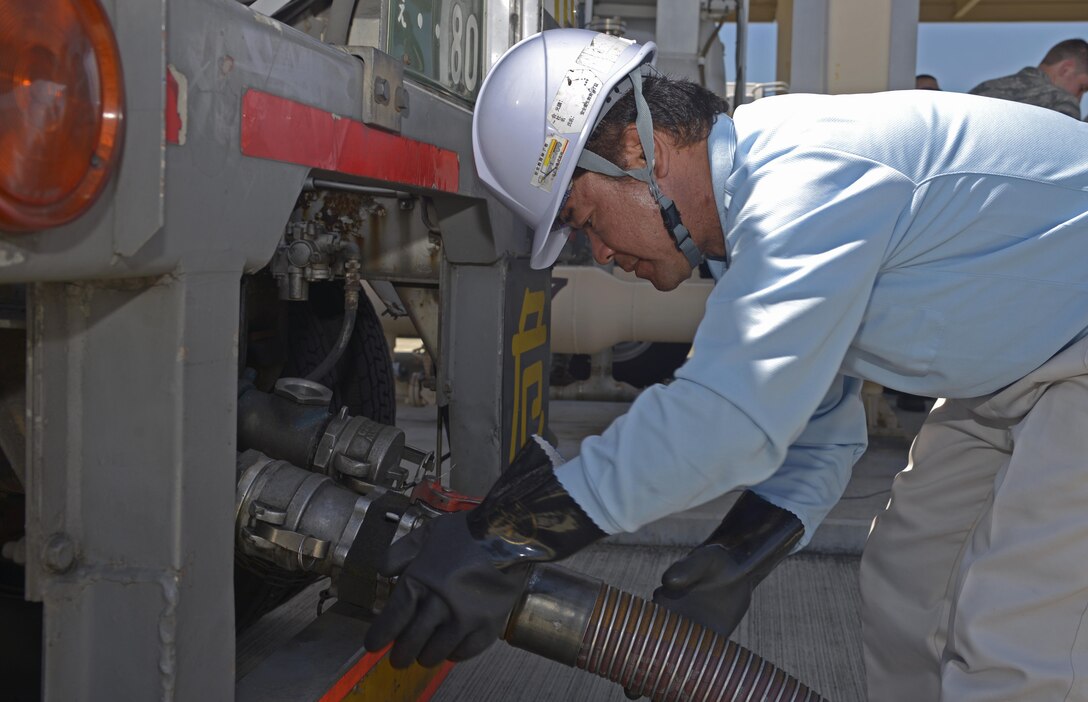 Toshikatau Yasukouchi, S.A. Logistic fuels technician, connects a hose to a fuel truck at Yokota Air Base, Japan, Aug. 17, 2016. The eight trucks delivered 40,000 gallons of fuel during the alternate receipt capability training. (U.S. Air Force photo by Senior Airman David Owsianka/Released)