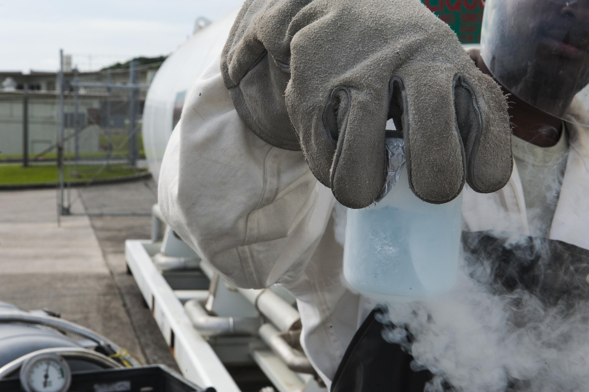 Senior Airman Brandon Avery, a cryogenics technician with the 18th Logistics Readiness Squadron, holds a sample of liquid oxygen for quality checking oxygen Aug. 17, 2016, at Kadena Air Base, Japan. Liquid oxygen is – 279 degrees Fahrenheit, and cannot be properly handled without use of proper personal protective equipment. (U.S. Air Force Photo by Airman 1st Class Nick Emerick)