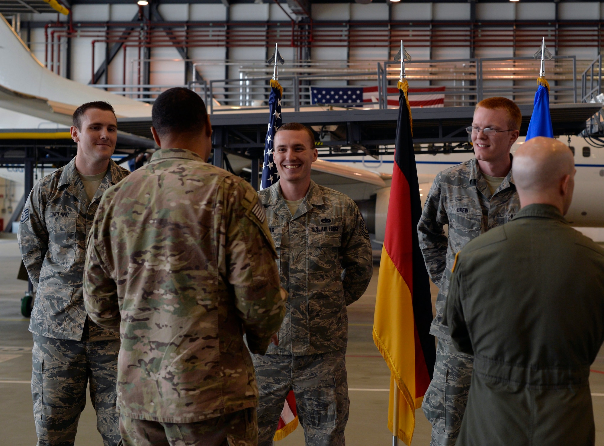 Airmen talk after a coin ceremony Aug. 10, 2016, Ramstein, Germany. Master Sgt. James McConaghay, U.S. Air Forces in Europe directorate contingency manager, Tech Sgt. David Hobeck, 86th Maintenance Squadron unit deployment manager, Tech Sgt. Austin Schierberg, 86th MXS repair and reclamation craftsman, Staff Sgt. Cory Garland, 86th MXS repair and reclamation journeyman and Staff Sgt. Geoffrey Brew, 86th MXS UDM were recognized for successful completion of an aircraft recovery mission. (U.S. Air Force photo/Senior Airman Nesha Humes)