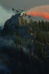 A California Air National Guard Modular Airborne Fire Fighting System (MAFFS) equipped C-130 drops retardant over Palm Springs Aerial Tramway to fight wildfire. 