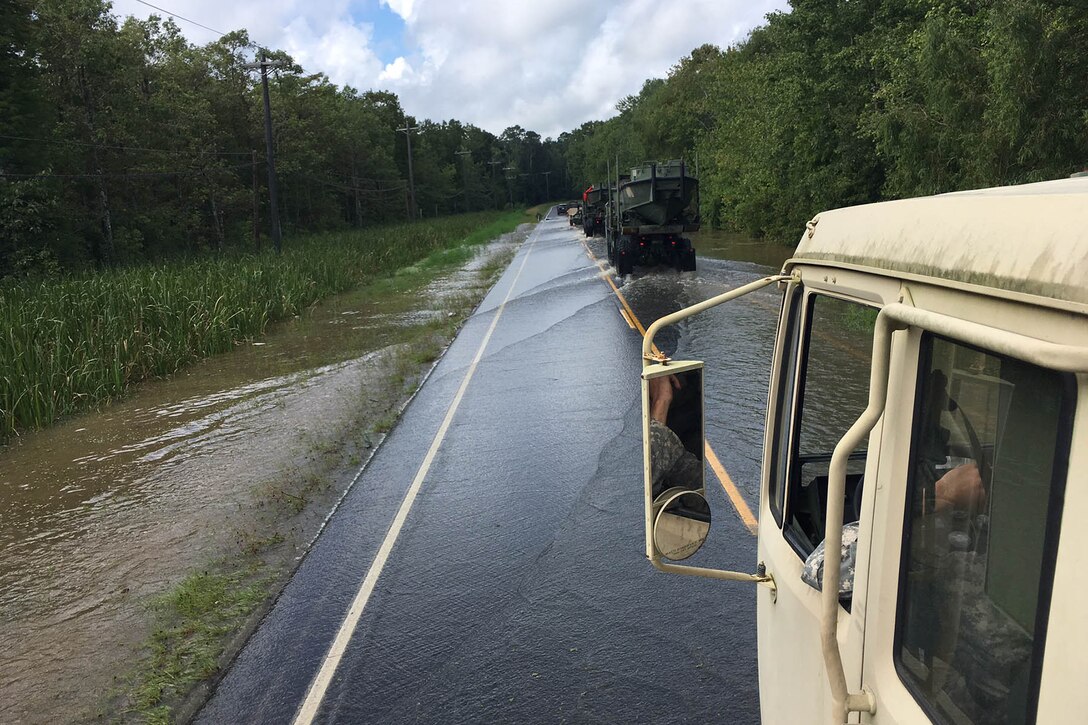 Louisiana National Guardsmen convoy to a boat launch in order to conduct door-to-door search and rescue missions near Maurepas, La., Aug. 17, 2016. National Guard photo by 1st Sgt. Paul C. Meeker