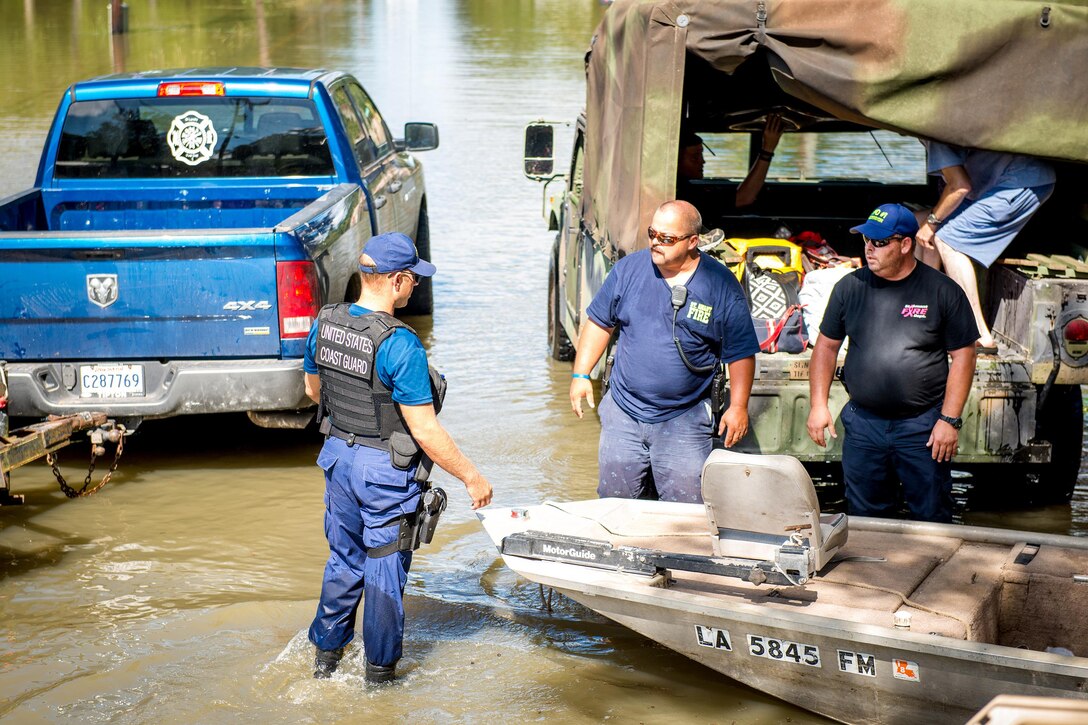 Coast Guard Chief Petty Officer Jonathan Tarroe, left, coordinates with members of the Saint Amant fire department and other local officials to evacuate stranded residents in Baton Rouge, La., Aug. 16, 2016. Members of the Coast Guard have provided assistance over several days during severe flooding. Tarroe is assigned to the Coast Guard Sector Lower Mississippi River. Coast Guard photo by Petty Officer 2nd Class LaNola Stone