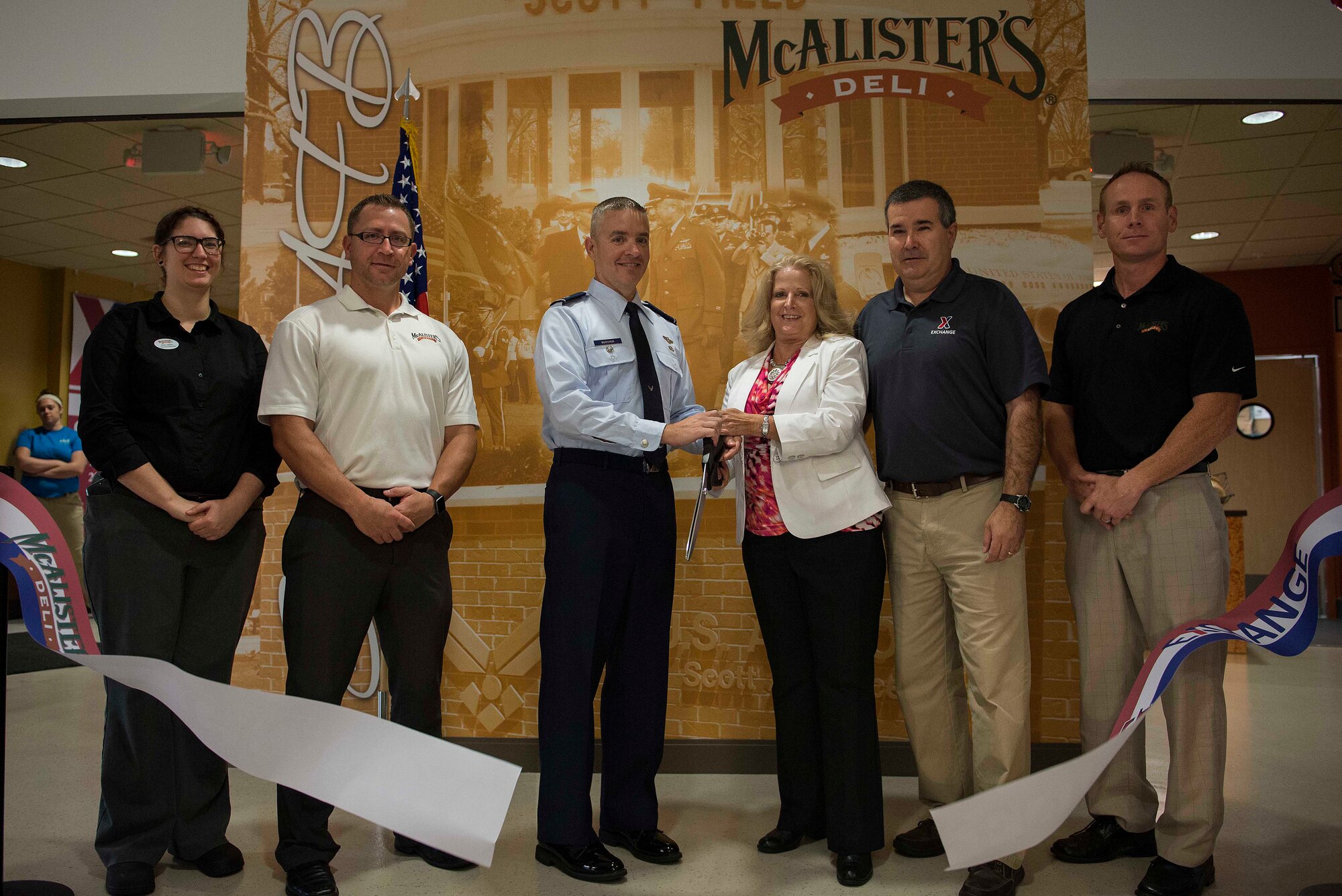(Left to right) Kim Allen, McAlister's general manager, Matt Fox, Midwest Deli Developments Inc. president, Col. Chris Buscher, 375th Air Mobility Wing vice commander, Paula Gunderson, Army and Air Force Exchange Service central region vice president, Dave Couture, Scott Air Force Base service business manager, and Adam Hubbard, Midwest Deli Developments area manager, cut the ribbon signifying the grand opening of the new McAlister's restaurant in the new Defense Informations Systems Agency building Aug. 15, 2016, at Scott Air Force Base, Ill. The restaurant is open to all who live and work at Scott Air Force Base. (U.S. Air Force photo/Senior Airman Jake Eckhardt)