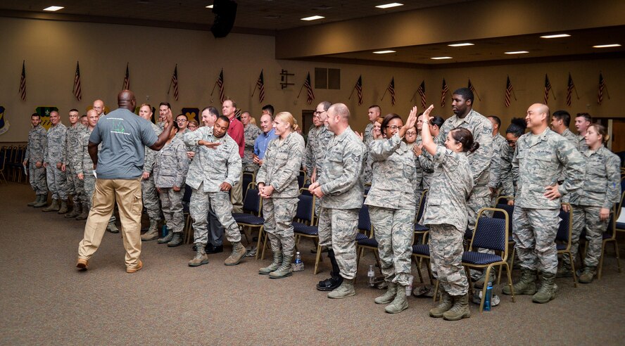 A Green Dot implementer congratulates Airmen, civilian workers, contractors and mission partners after completing Green Dot general overview training at Barksdale Air Force Base, La., Aug. 9, 2016. Each training had hands-on activities focused on reinforcing the content to enhance comprehension and provide tools for members to use in real world situations. (U.S. Air Force photo/Senior Airman Mozer O. Da Cunha)