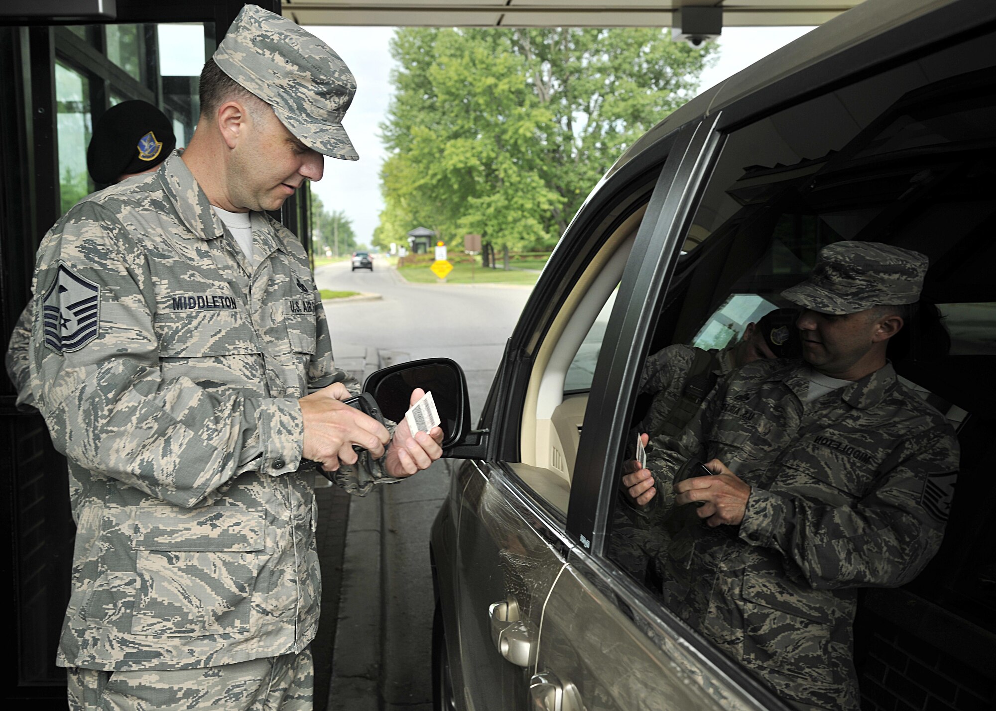 Master Sgt. Stephen Middleton, 319th Security Forces Squadron first sergeant, checks identification cards at the main gate, Aug. 16, 2016, on Grand Forks Air Force Base, N.D. Middleton is studying to learn how to qualify to become an installation entry controller to better understand the SFS career field. (U.S. Air Force photo by Senior Airman Xavier Navarro/Released)